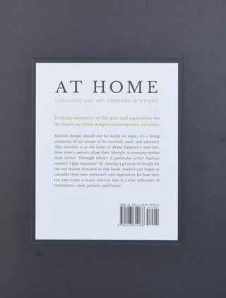 At Home Evocative and Art-Forward Interiors back cover with brown background and description in the middle.