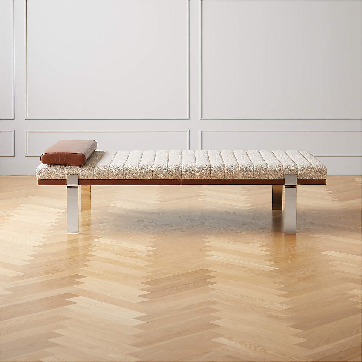 Upholstered in a classic cream-colored boucle, with decorative leather sling straps adding a material-driven touch with contrast.