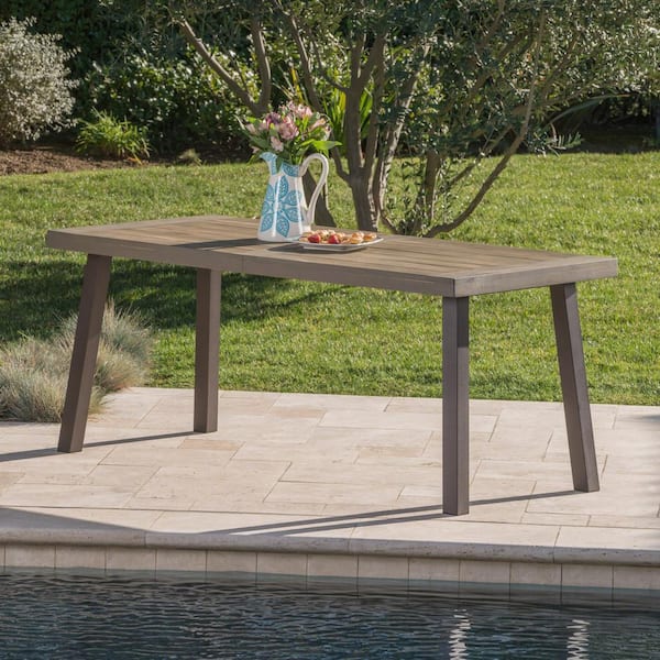 Front view of grey wooden outdoor dining table with tapered legs.