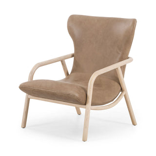 tan top-grain leather forms a scooped seat and dramatic wing back, with a whitewashed ash frame finishing things off with cool monochromatic vibes.