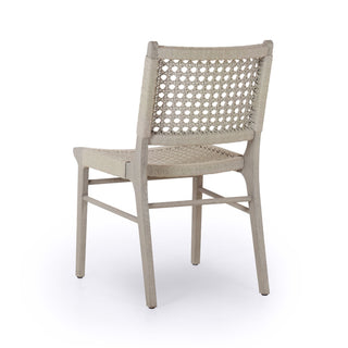 Outdoor chair made of weathered grey teak frames woven ivory rope, making a texture-driven statement.